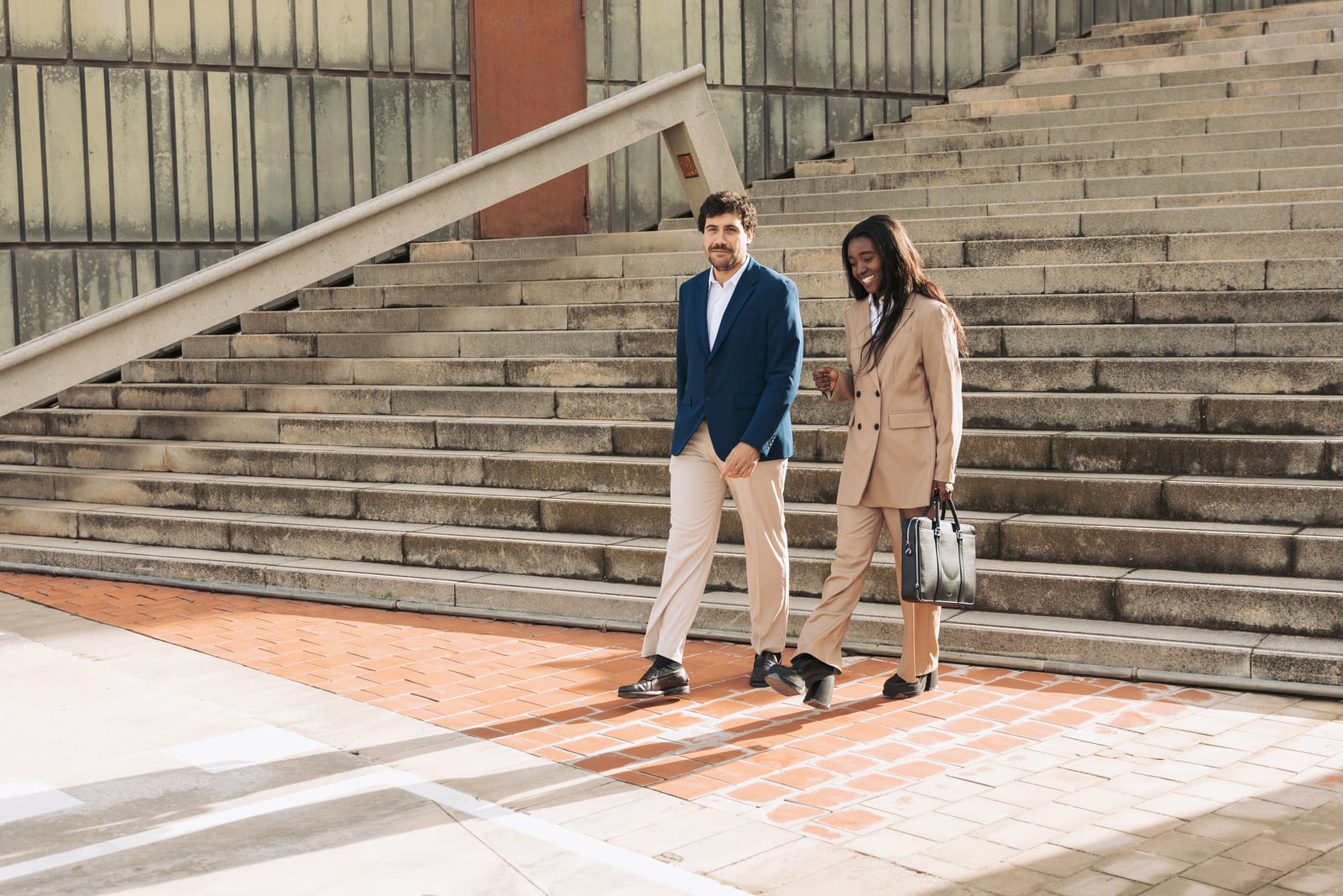 Two professionals walking outside a building